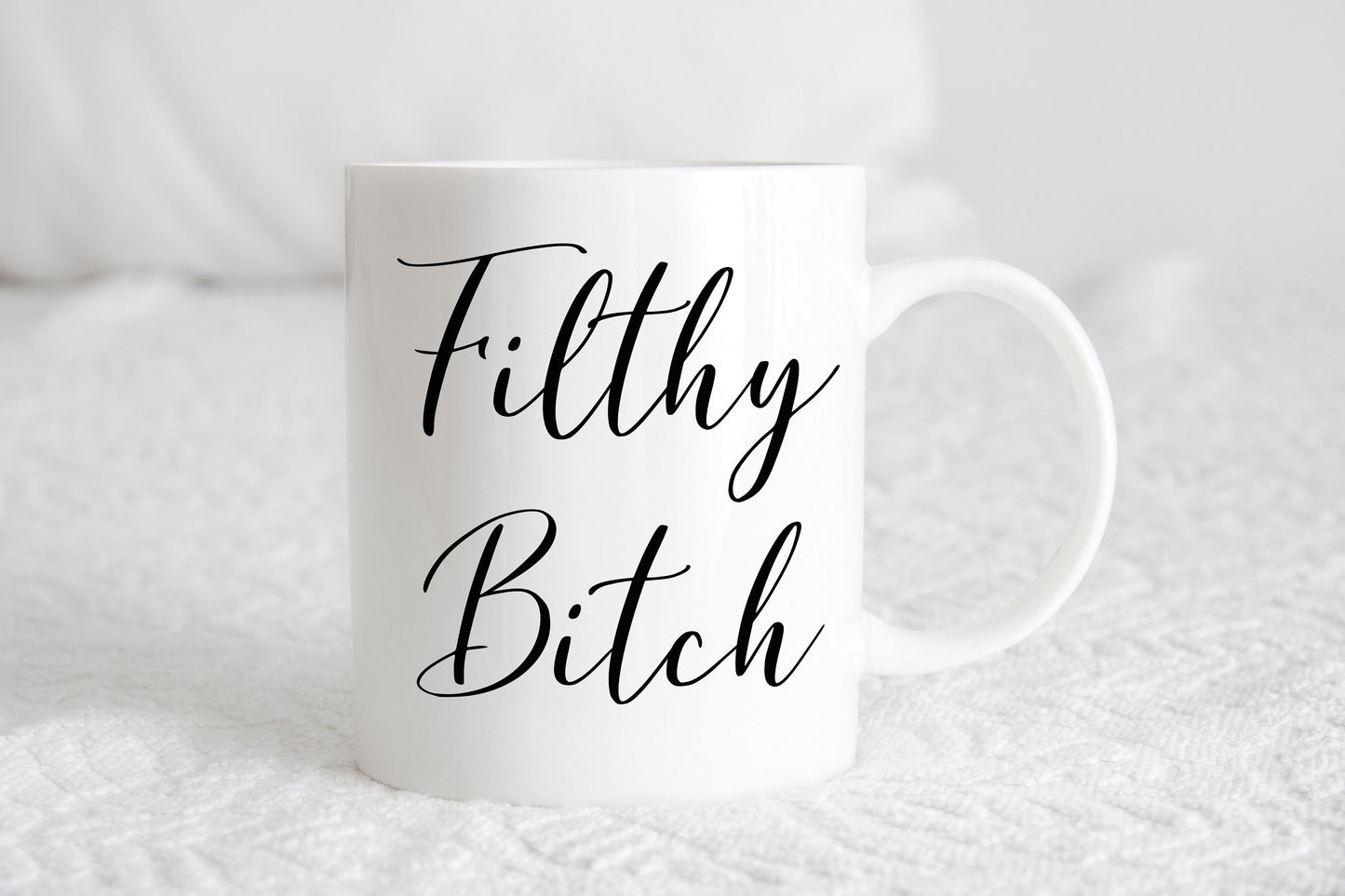 A white ceramic mug with the phrase 'Filthy Bitch' printed in black script.