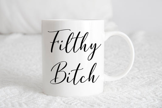A white ceramic mug with the phrase 'Filthy Bitch' printed in black script.