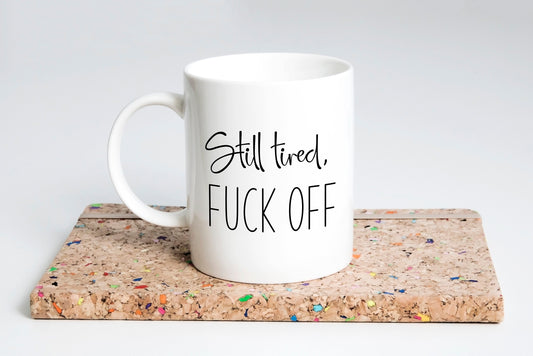 “Still Tired, F*ck Off coffee mug with bold text”
